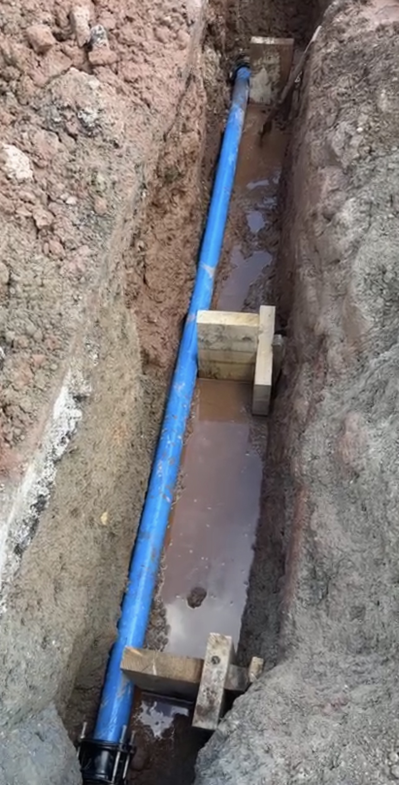 Blue water main laid in open trench on site