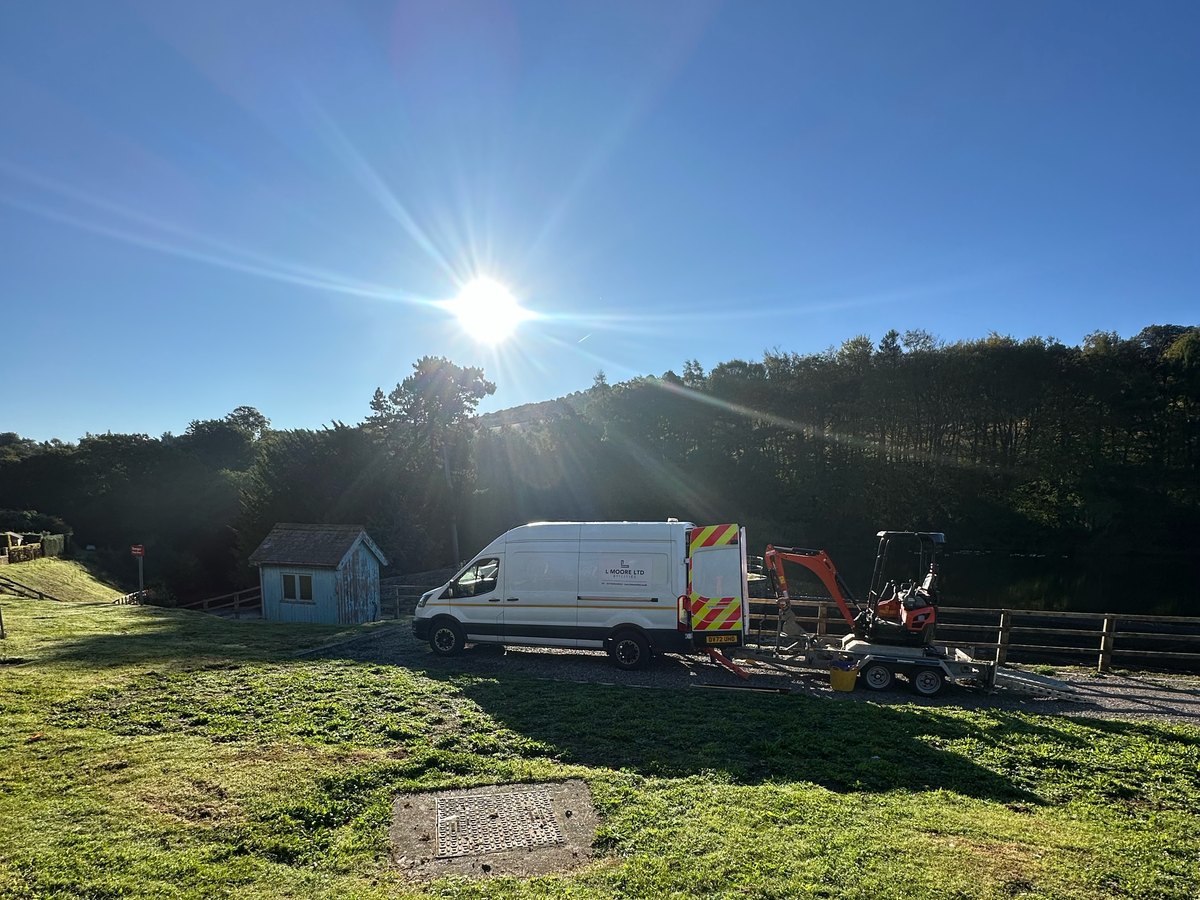 L Moore Ltd van and mini digger on site beside a chamber